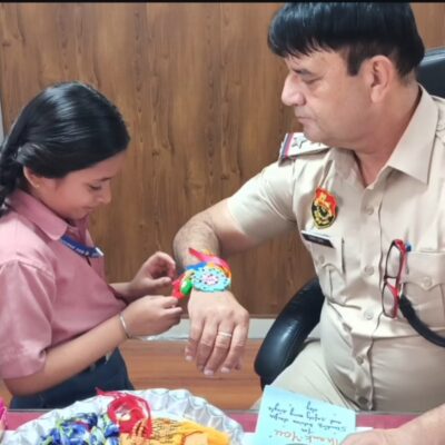 A Thread of Respect: A student tying a Rakhi to a police officer, honoring their unwavering commitment to our safety.